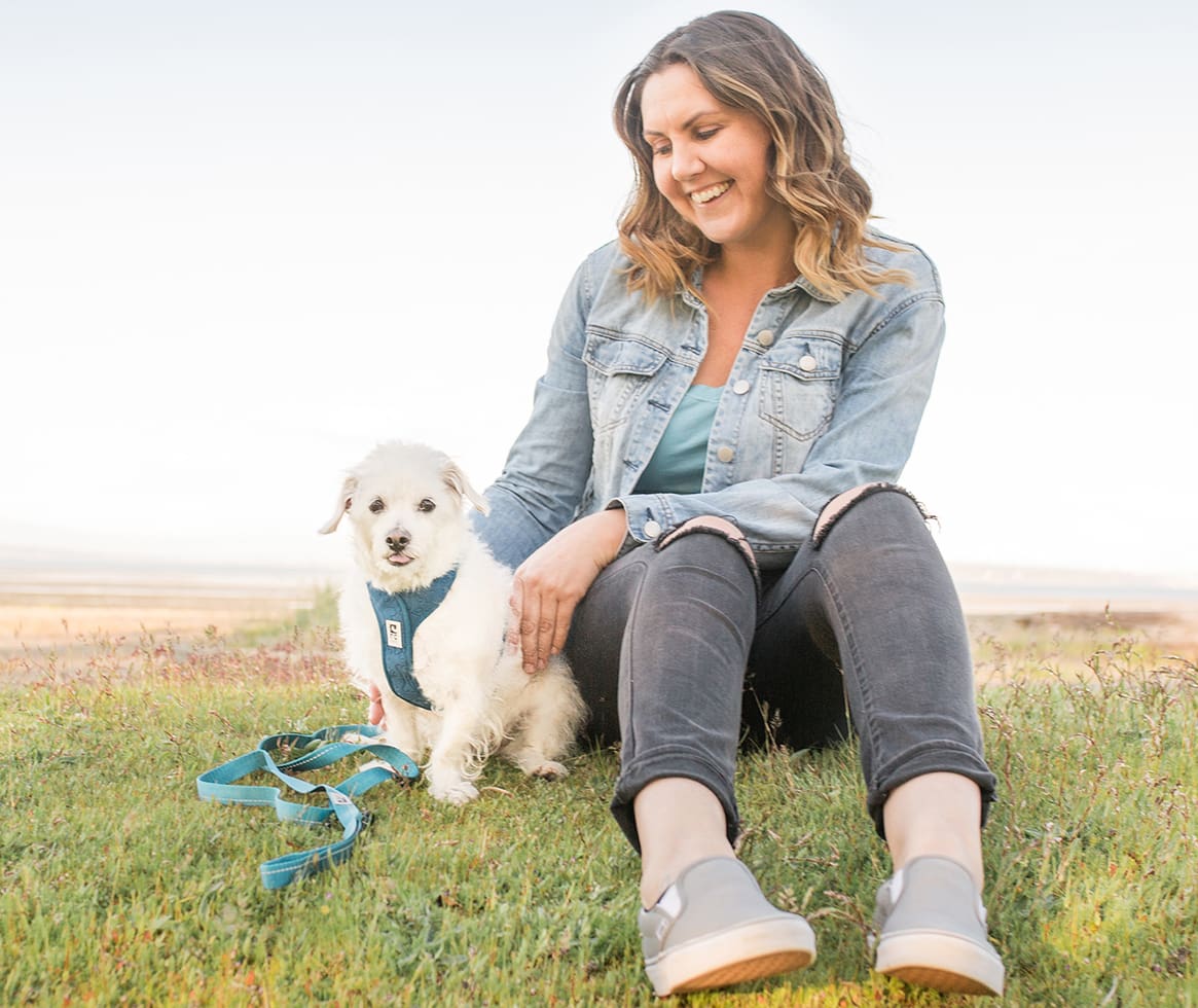 Woman sitting in grass with dog